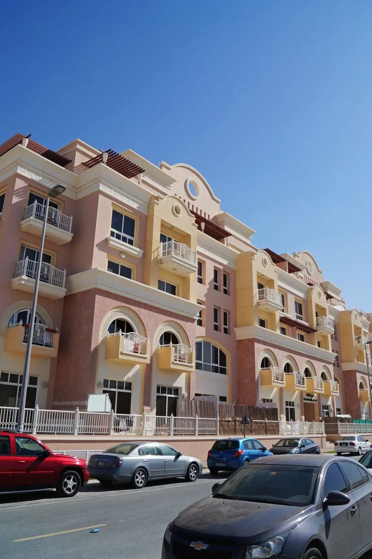 Street view of pink-cream Mulberry building, arched balconies