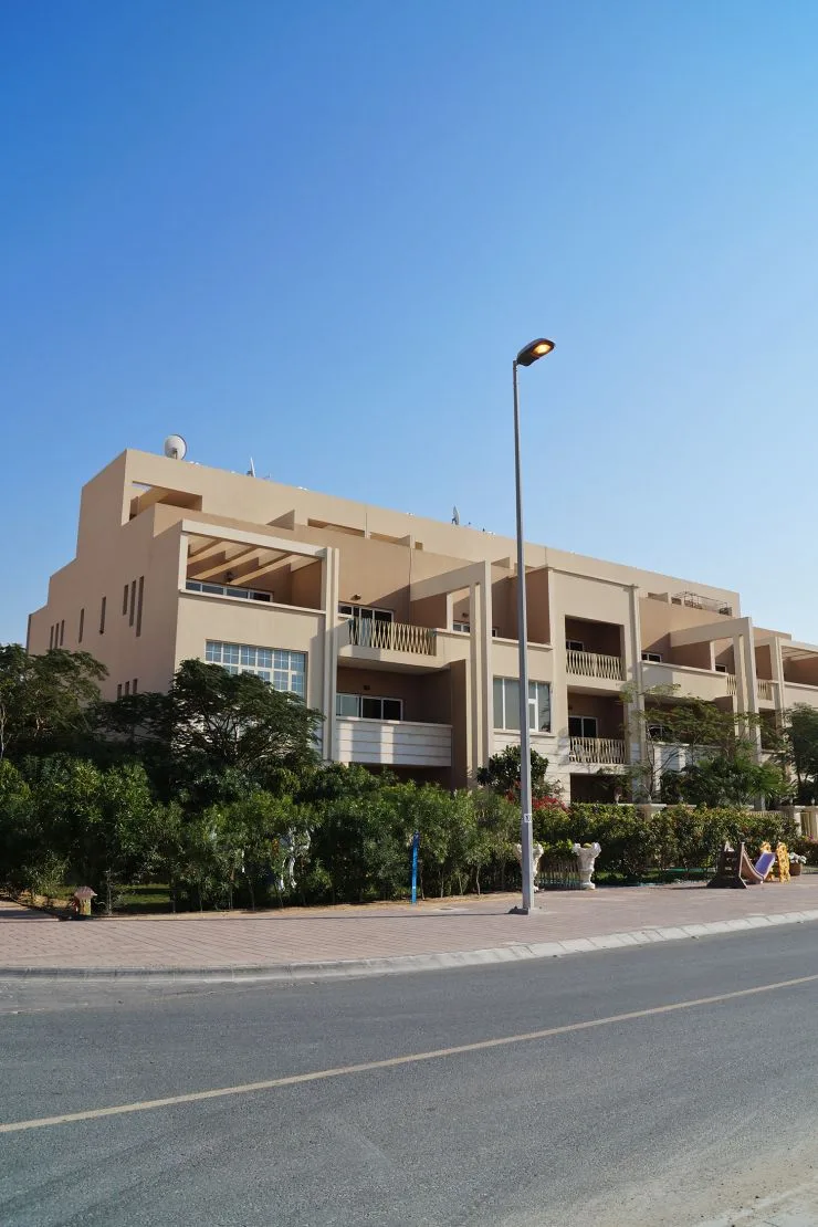 Beige low-rise townhouse block seen from the street