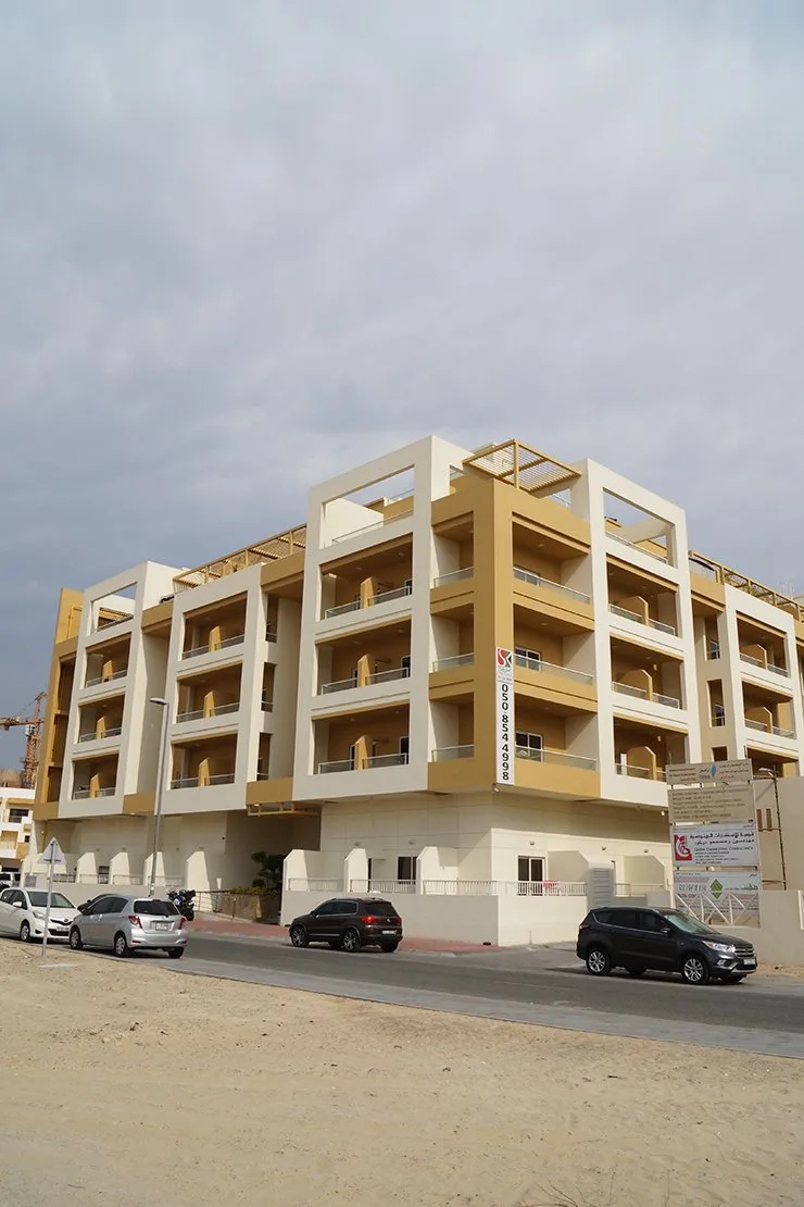 Five-storey cream and ochre apartment building with balconies