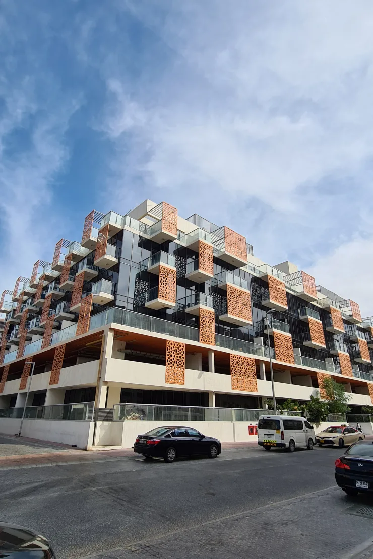 Corner view of building with orange perforated screens