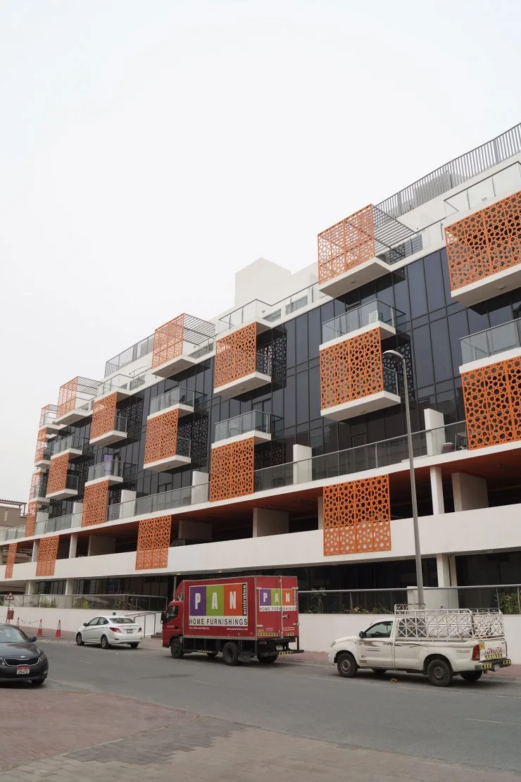 Street-side facade with orange screens and balconies