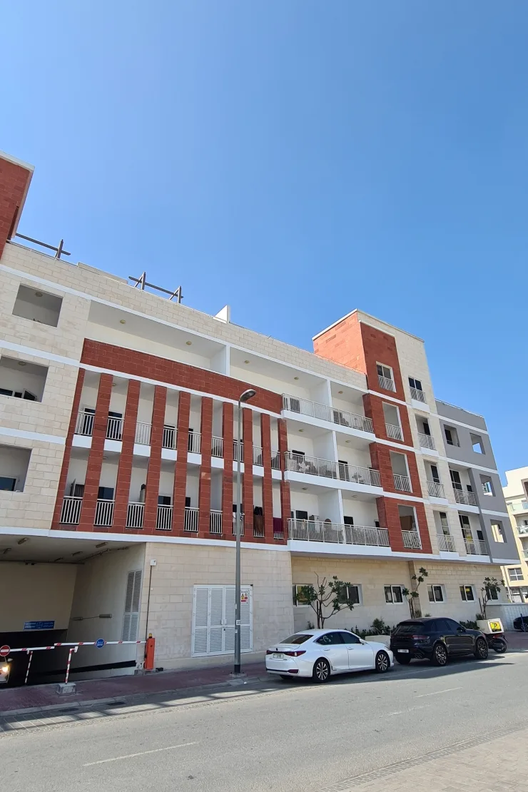 Street-side facade with red brick fins and parking entrance
