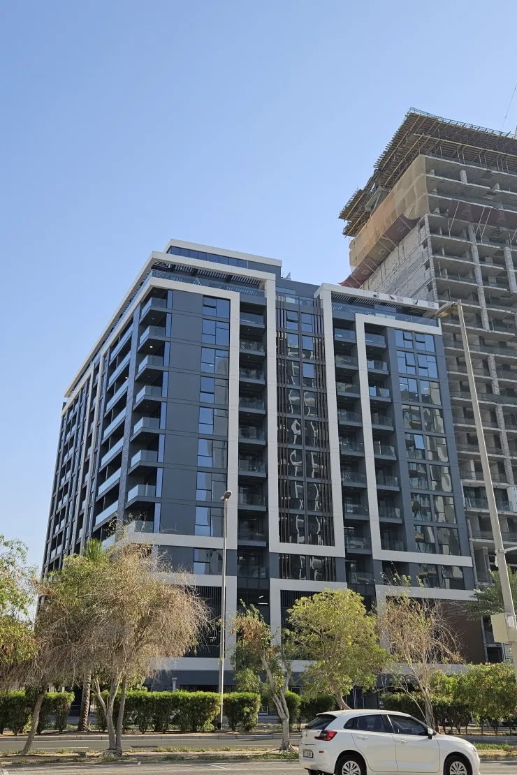 Completed tower from street, dark facade, white frames