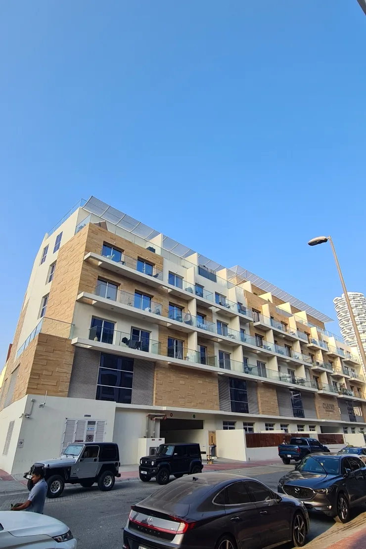 Corner of the building with balconies and stone cladding