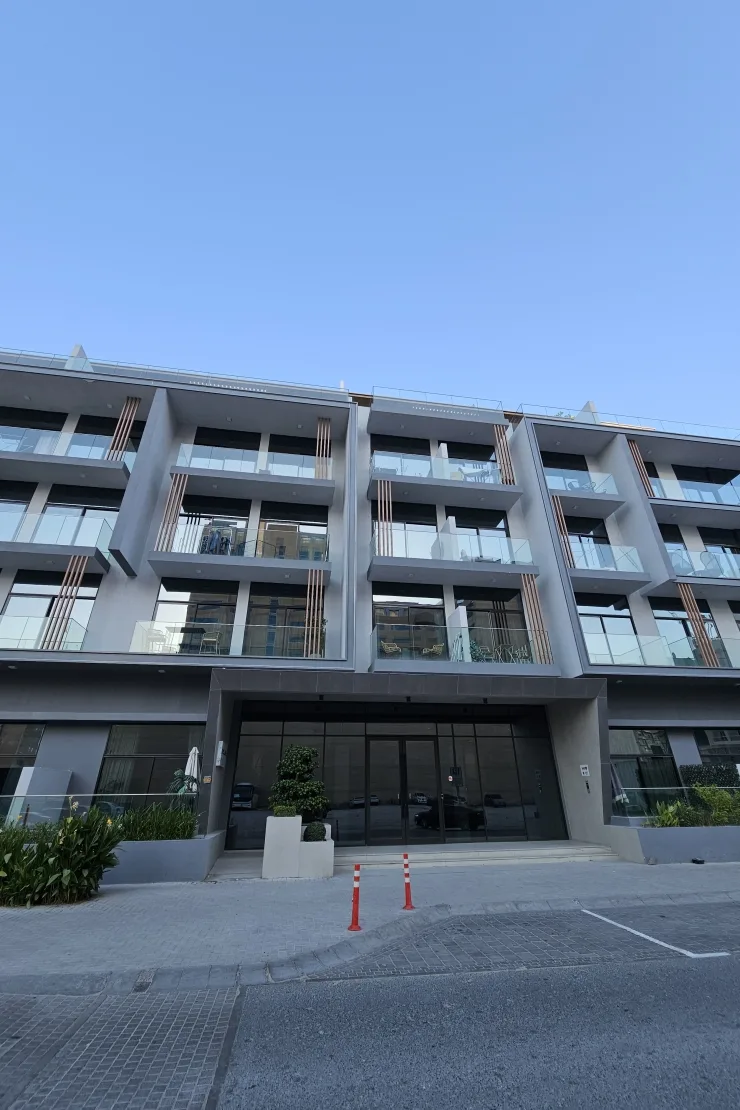 Front facade with entrance, glass balconies, timber fins
