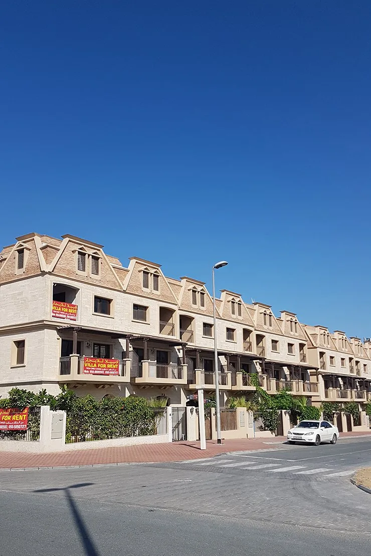 Completed mansard-roof townhouse row, street view