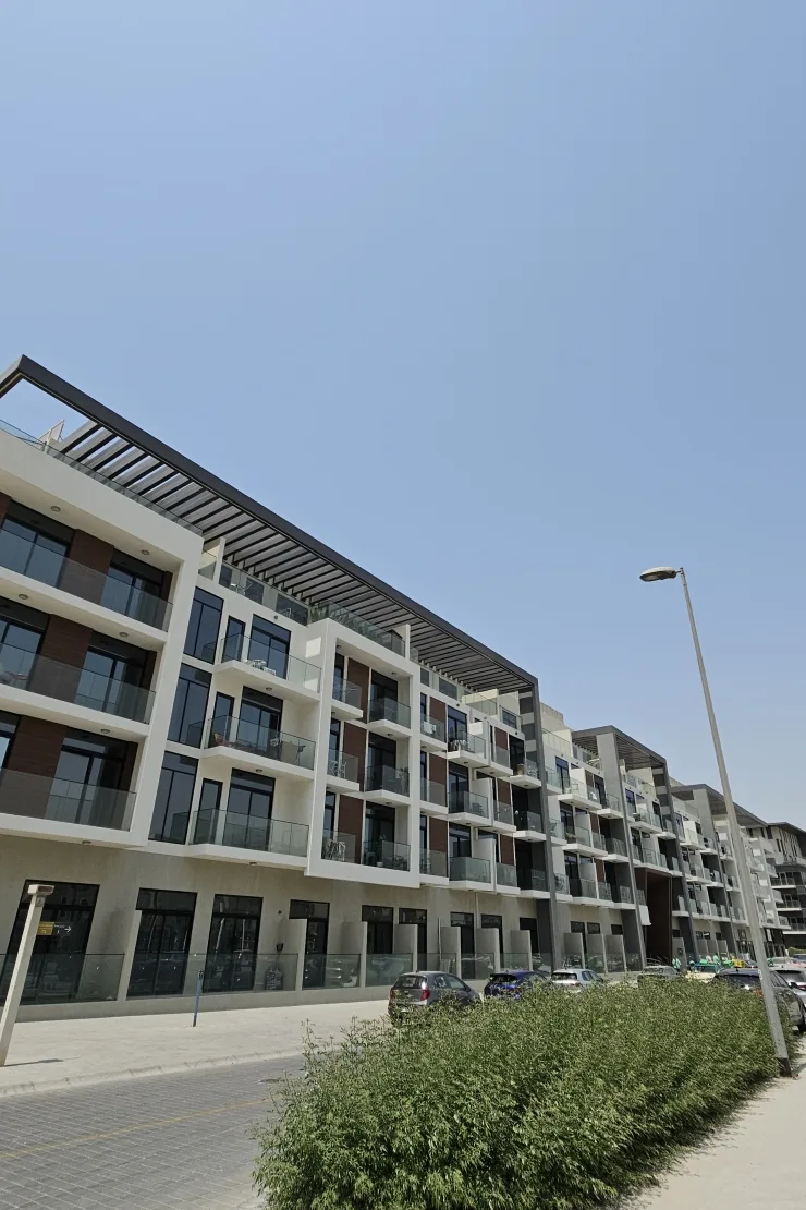 Completed building facade with timber panels and pergola roof