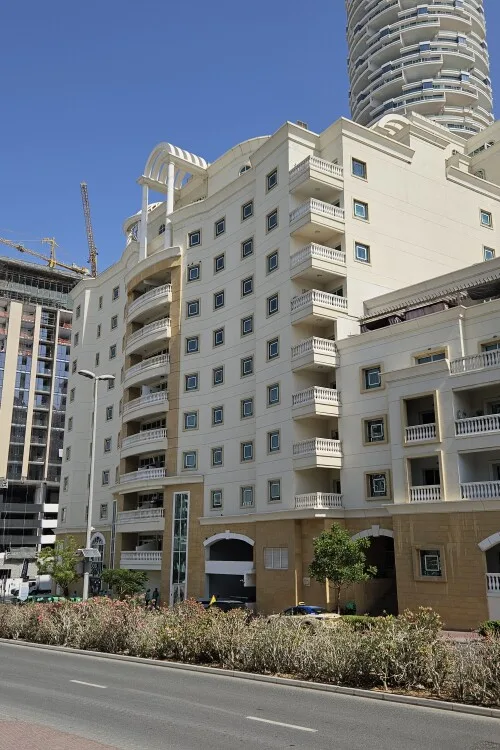 Street view of cream facade with arched balconies