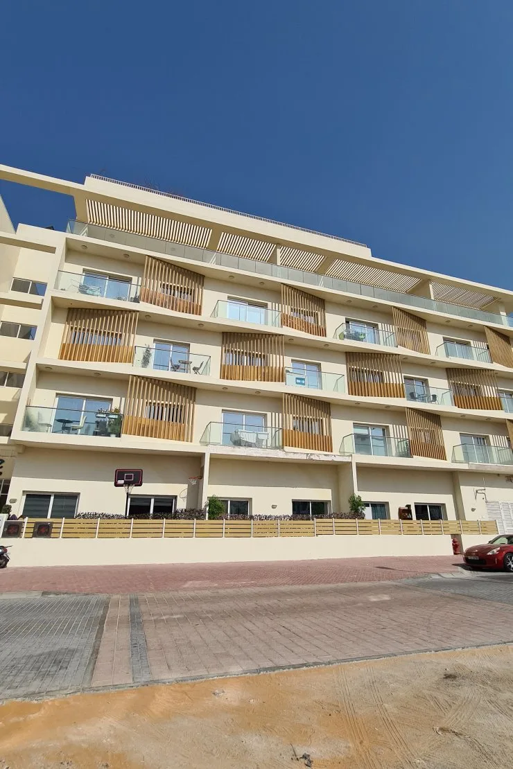 Full facade with timber louvres and glass balconies
