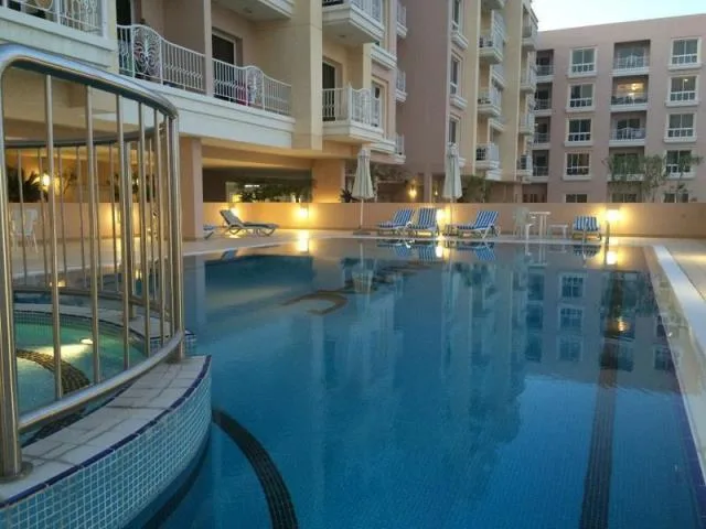 Pool with matching peach buildings and white balconies