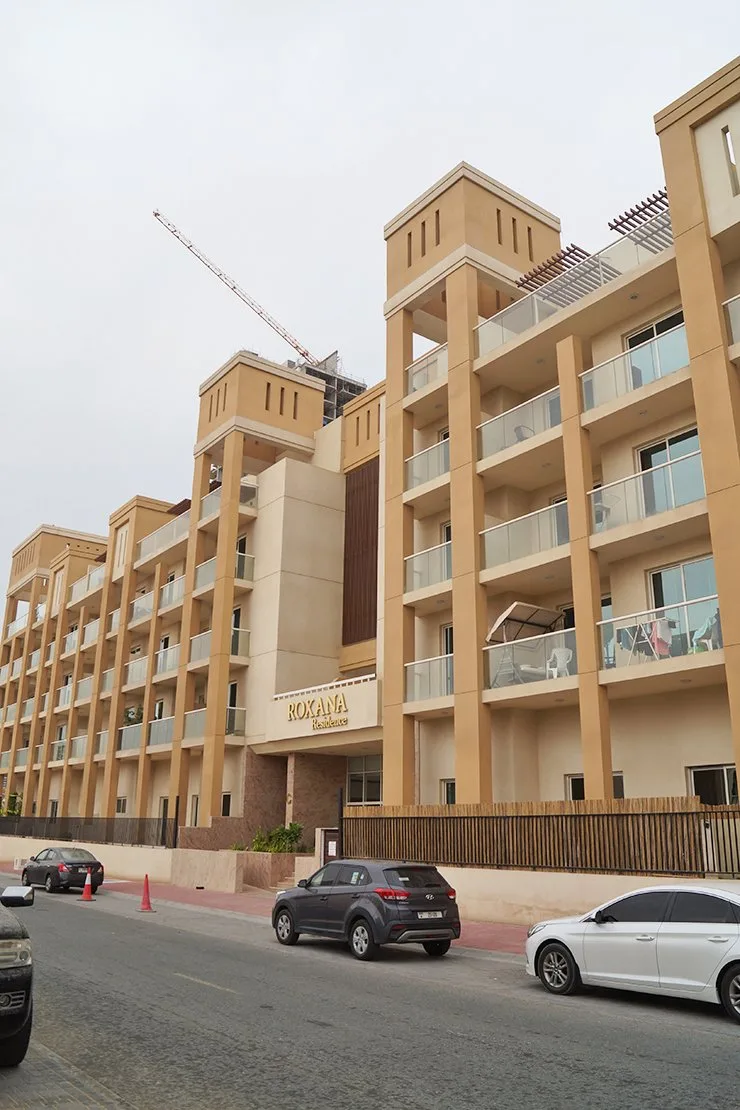 Beige tower-style facade with Roxana Residence signage