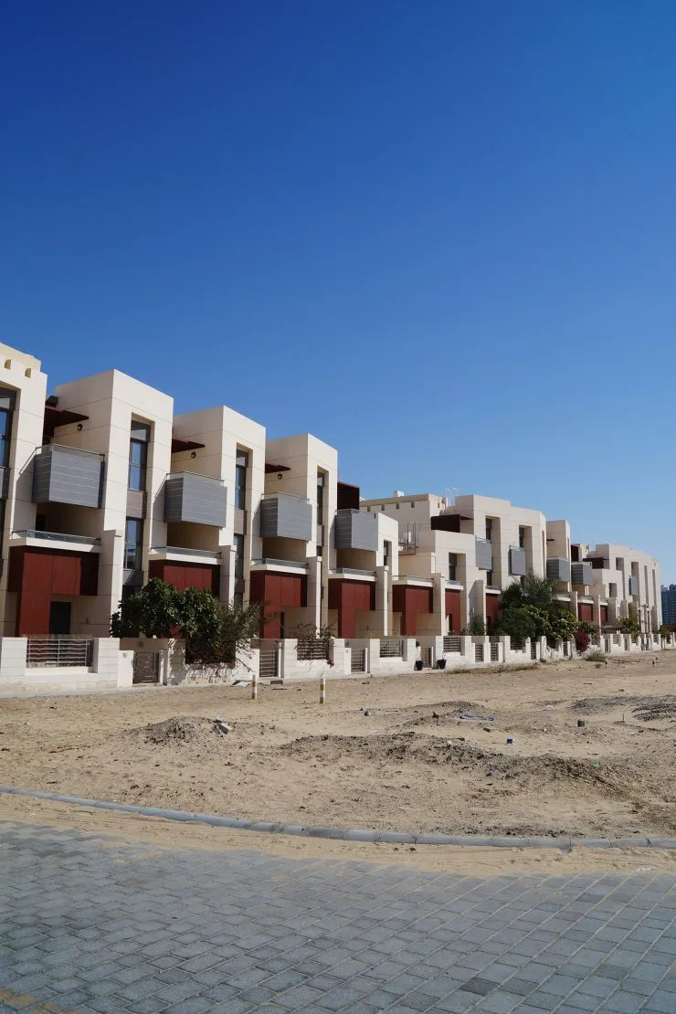 Row of cream townhouses with grey balconies and rust panels