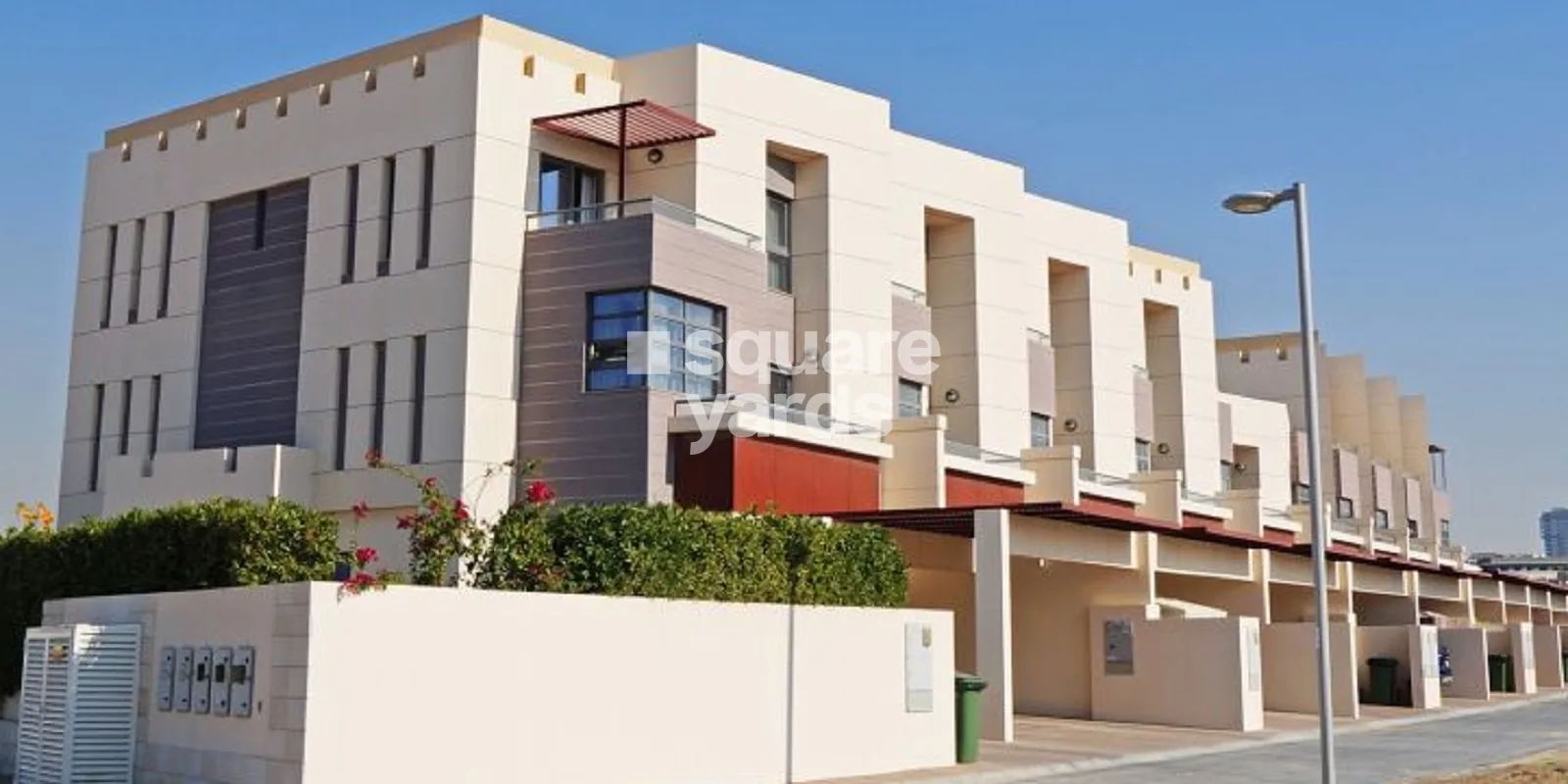 Corner townhouse block with cream facade and red accents