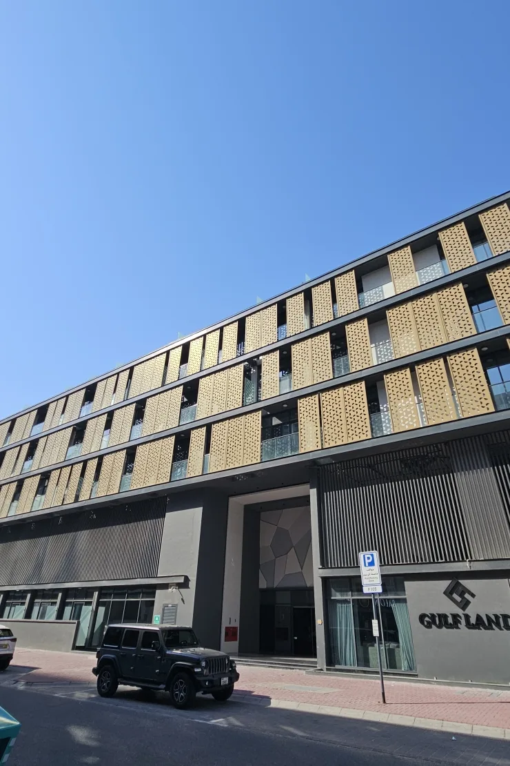 Completed facade with gold screens and Gulf Land signage
