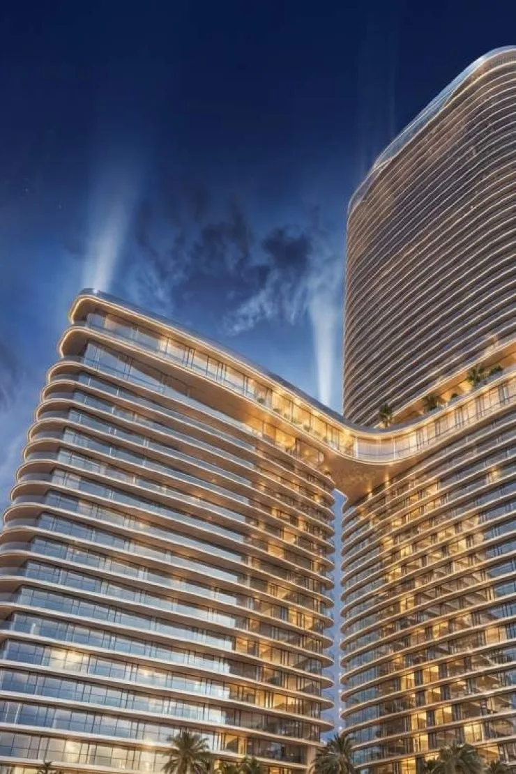 Curved-balcony towers joined by bridge at dusk