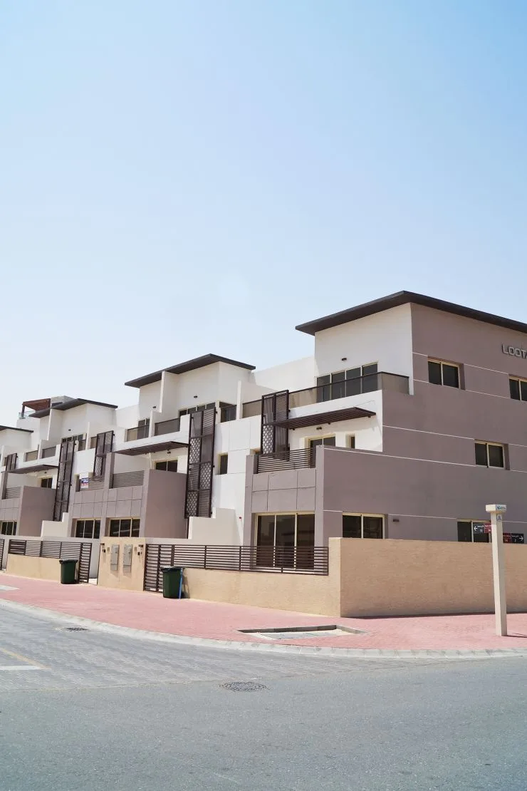 Terraced white and taupe townhouses from street corner