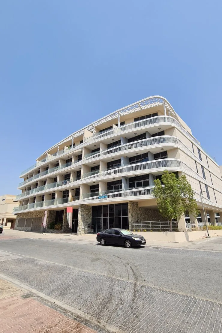 Curved facade from street with stone-clad ground floor