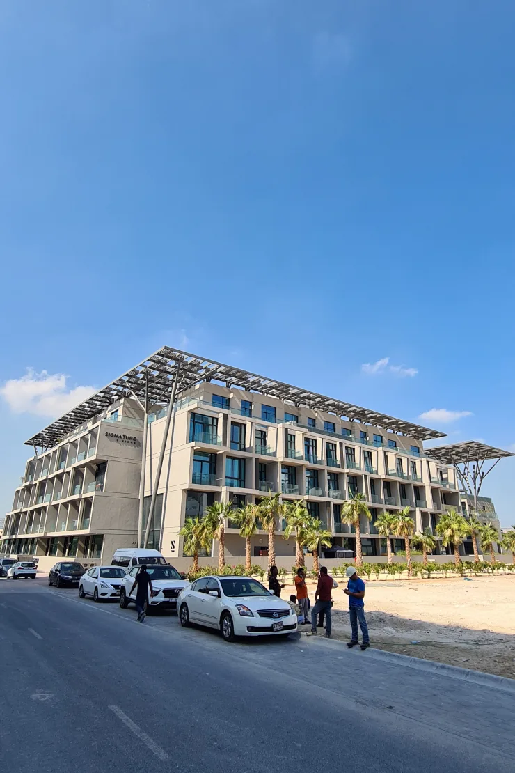 Long facade with palms and canopy roof