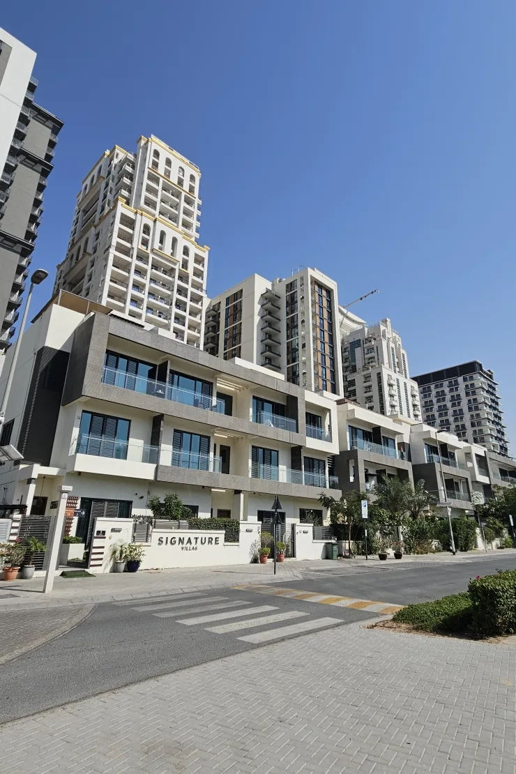 Signature Villas entrance sign and townhouse facade, towers behind