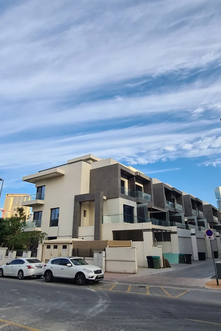 Corner villa block with grey cladding and balconies