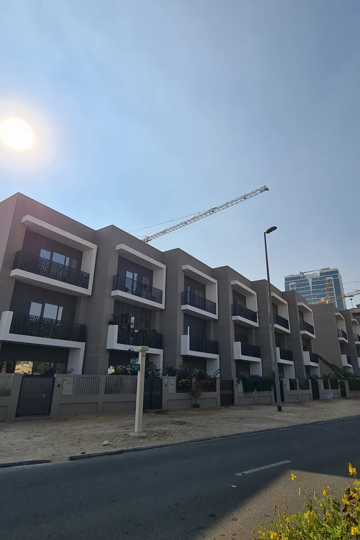 Front facade of completed townhouse row with balconies