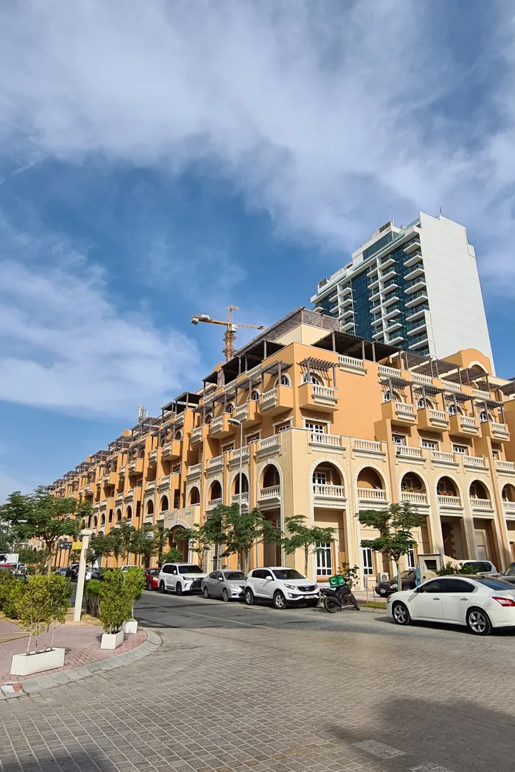Street view of long orange arched facade with balconies