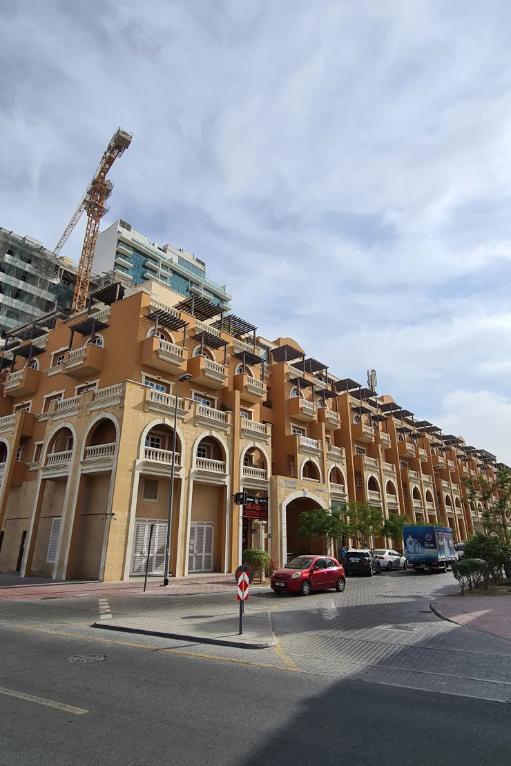 Orange arched facade with balconies from street corner