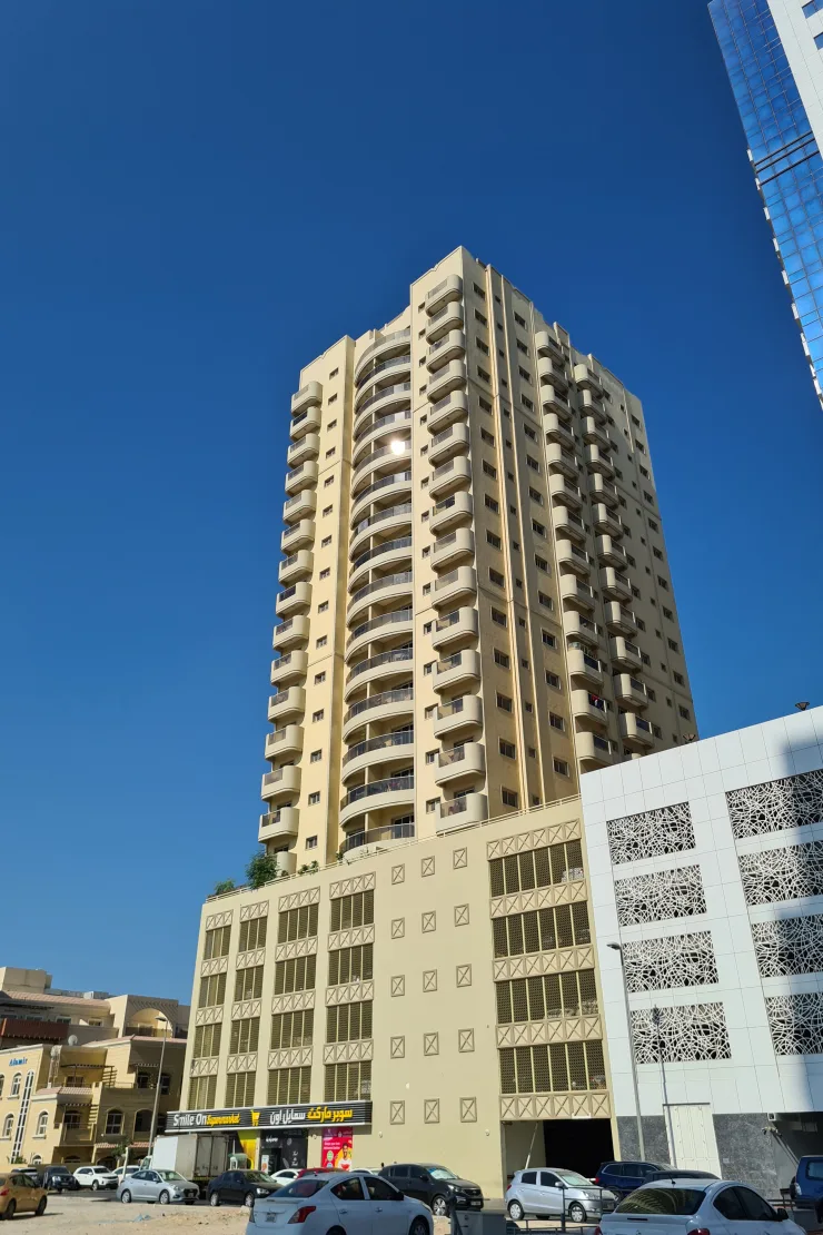 Cream tower with curved balconies above podium