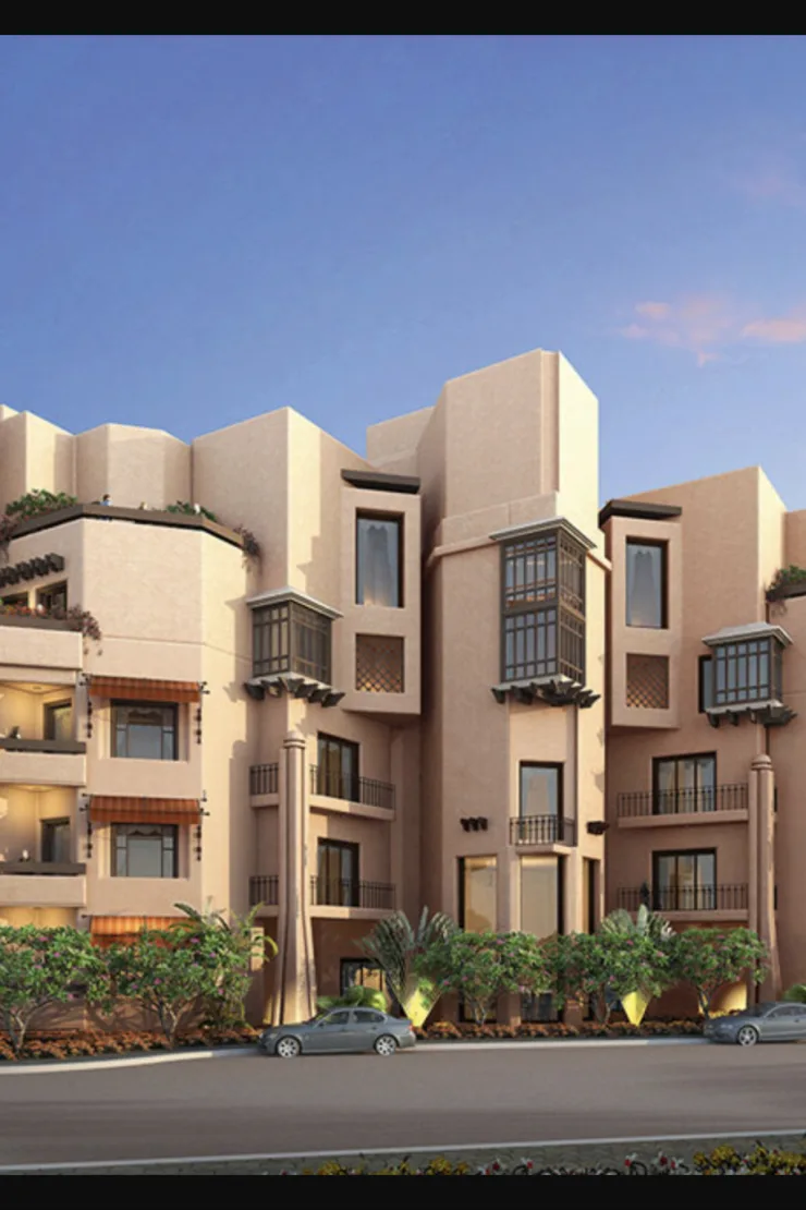 Earth-toned low-rise with mashrabiya bay windows, street view