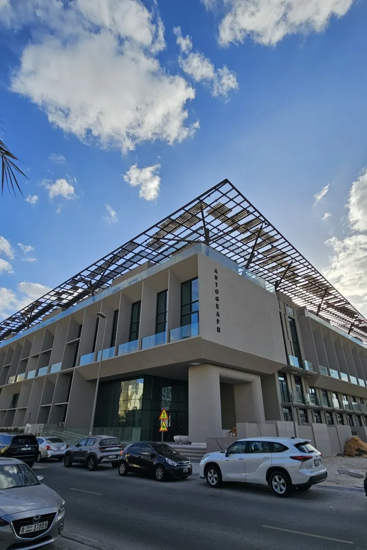 Corner of completed building with solar canopy and signage