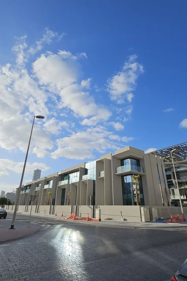 Completed townhouse row with glass balconies, street view