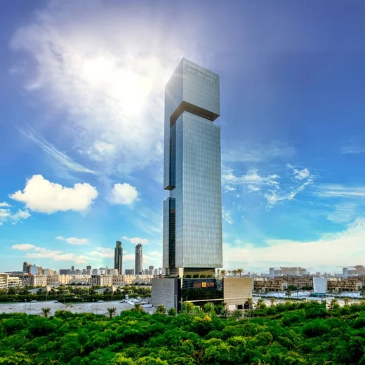 Tower and podium seen above greenery