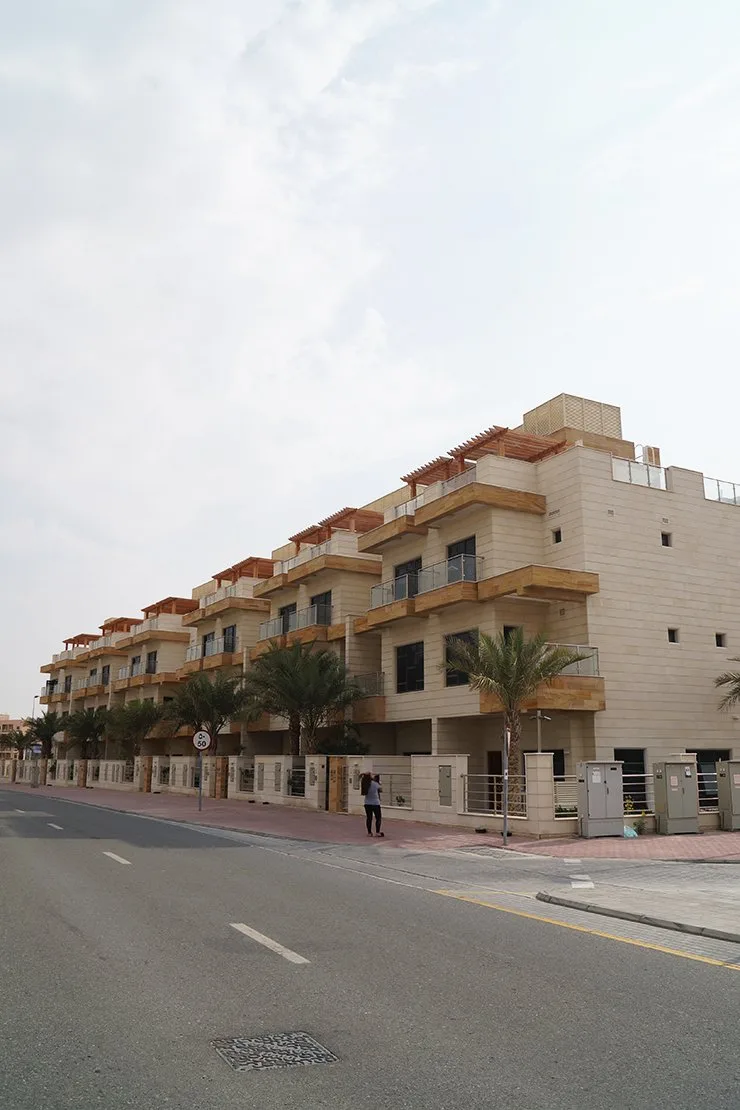 Row of cream stone townhouses with pergolas