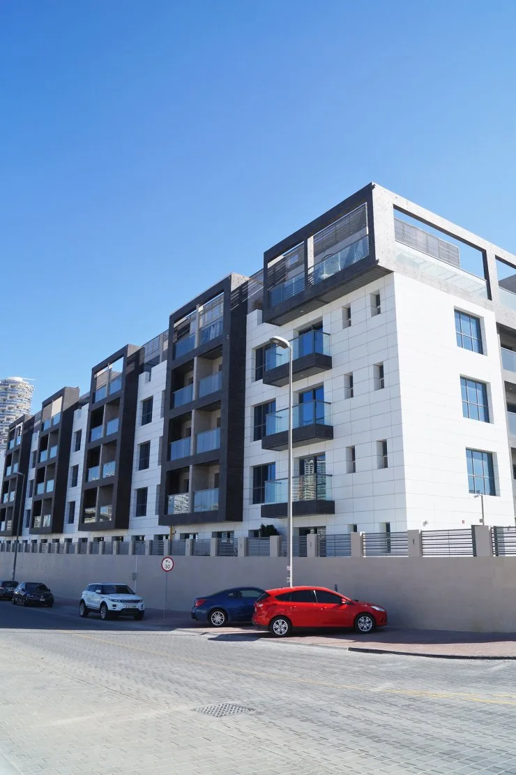 Mid-rise white and dark-framed facade from street