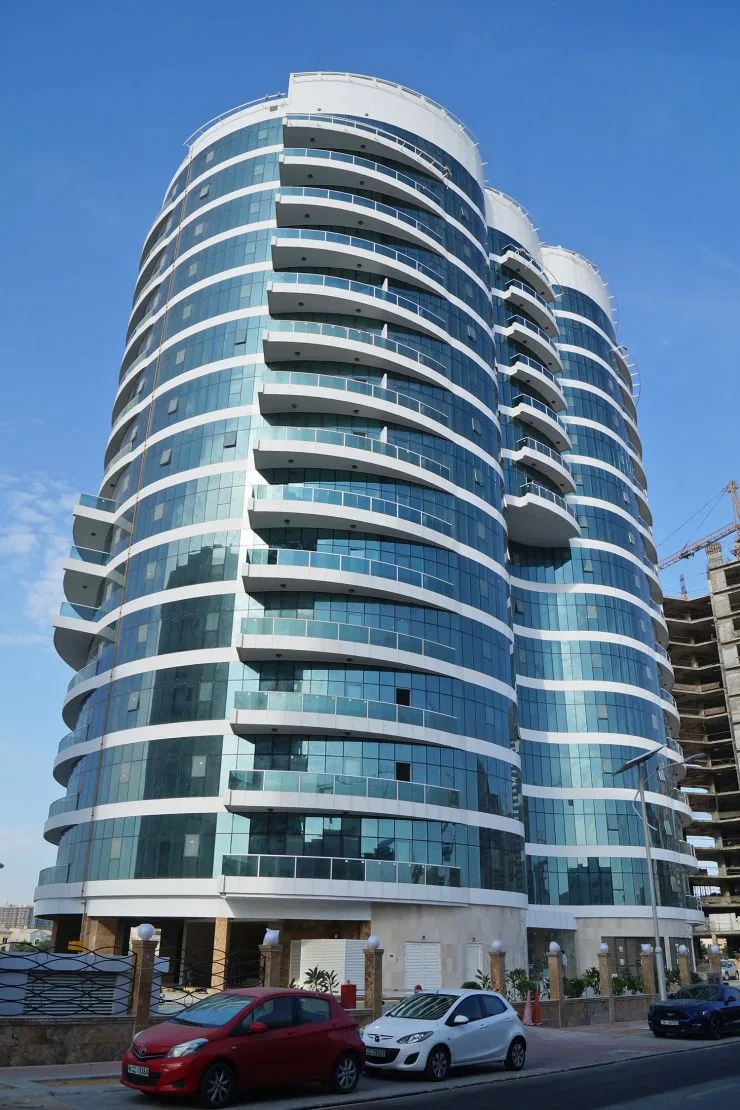 Completed curved glass tower with balconies, full height
