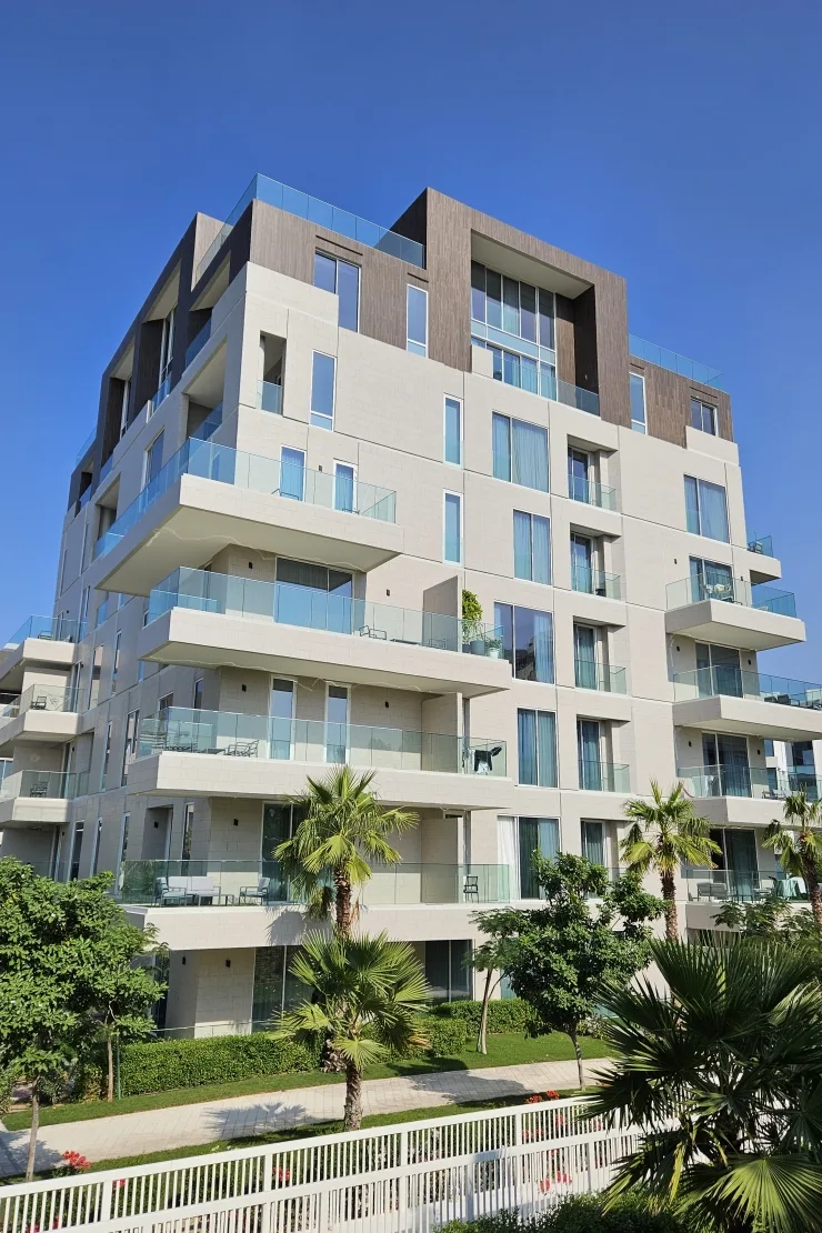 Beige and brown mid-rise with glass balconies, ground to roof
