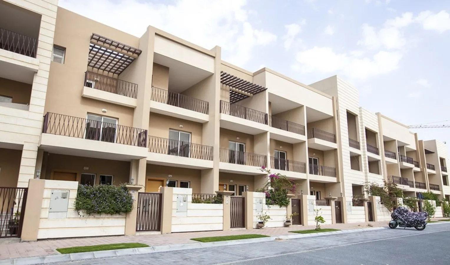 Beige townhouse row with balconies and pergolas