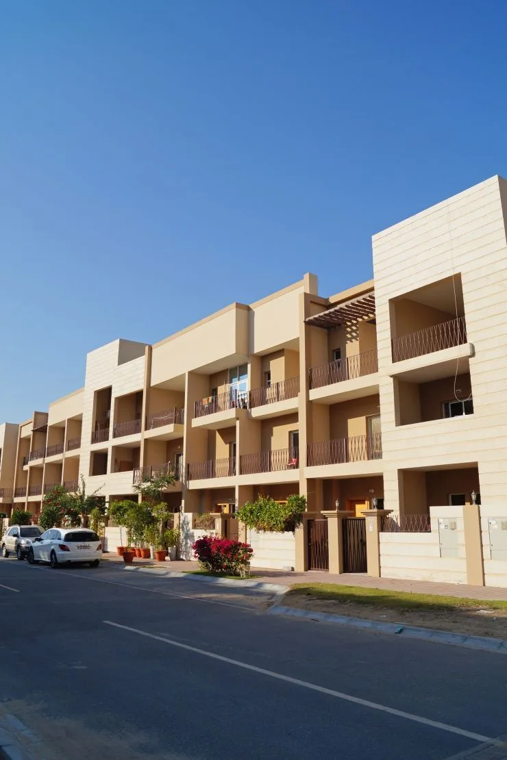 Street view of beige stone-clad townhouse block