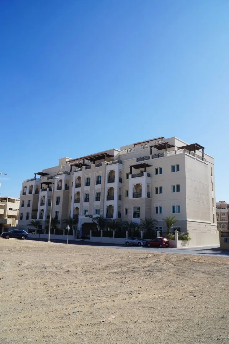 Cream five-storey building with Valencia sign and pergolas