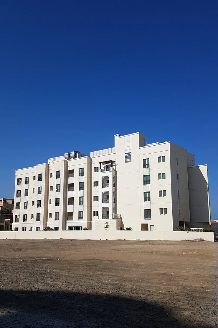 Side and rear facade, cream with balcony tower and pergola