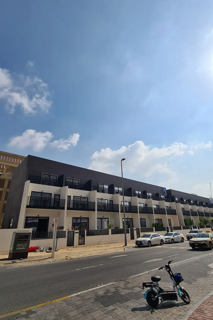 Completed three-storey townhouse row with dark top and balconies