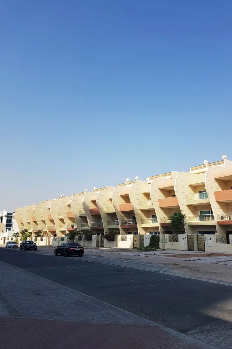 Curved cream terraced townhouse row seen from the street