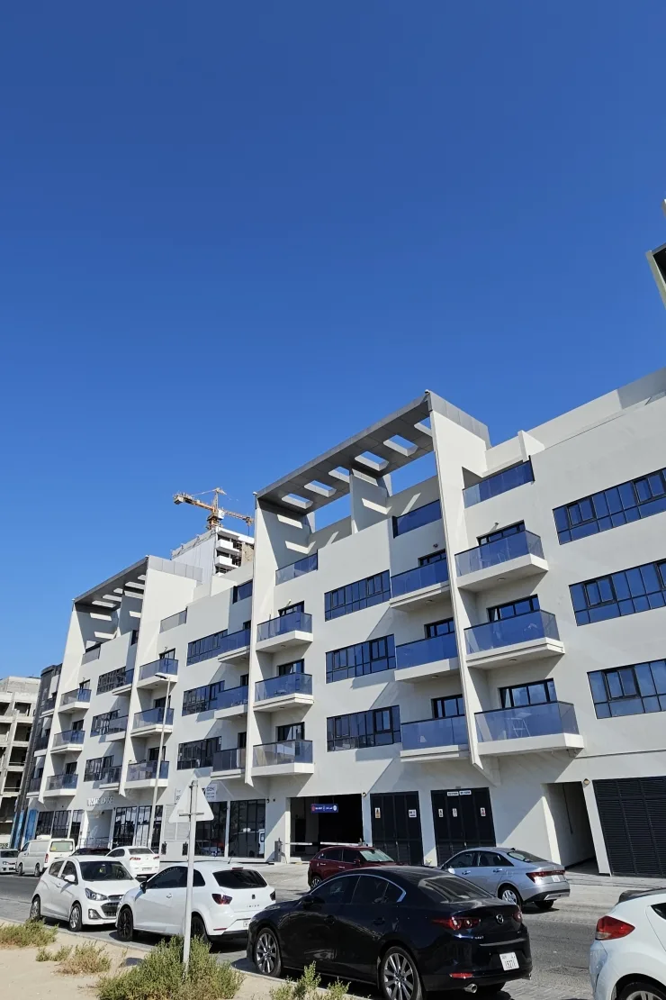 Long street facade, blue-glass balconies, roof pergolas