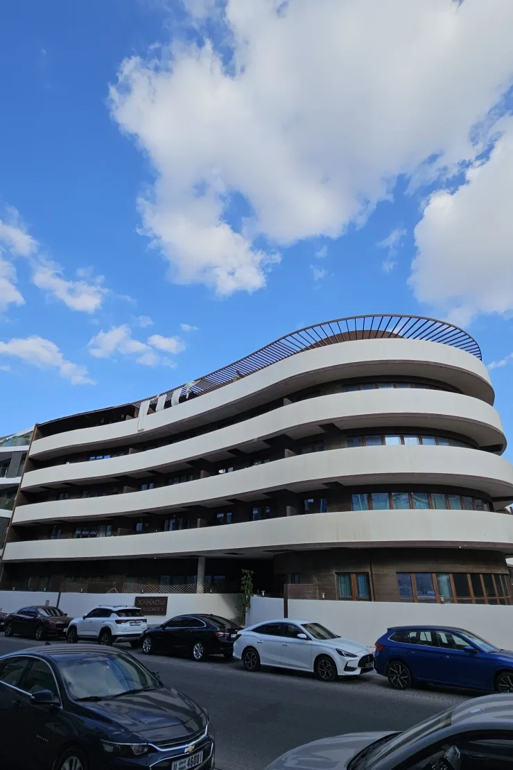 Curved white balconies, completed building from street