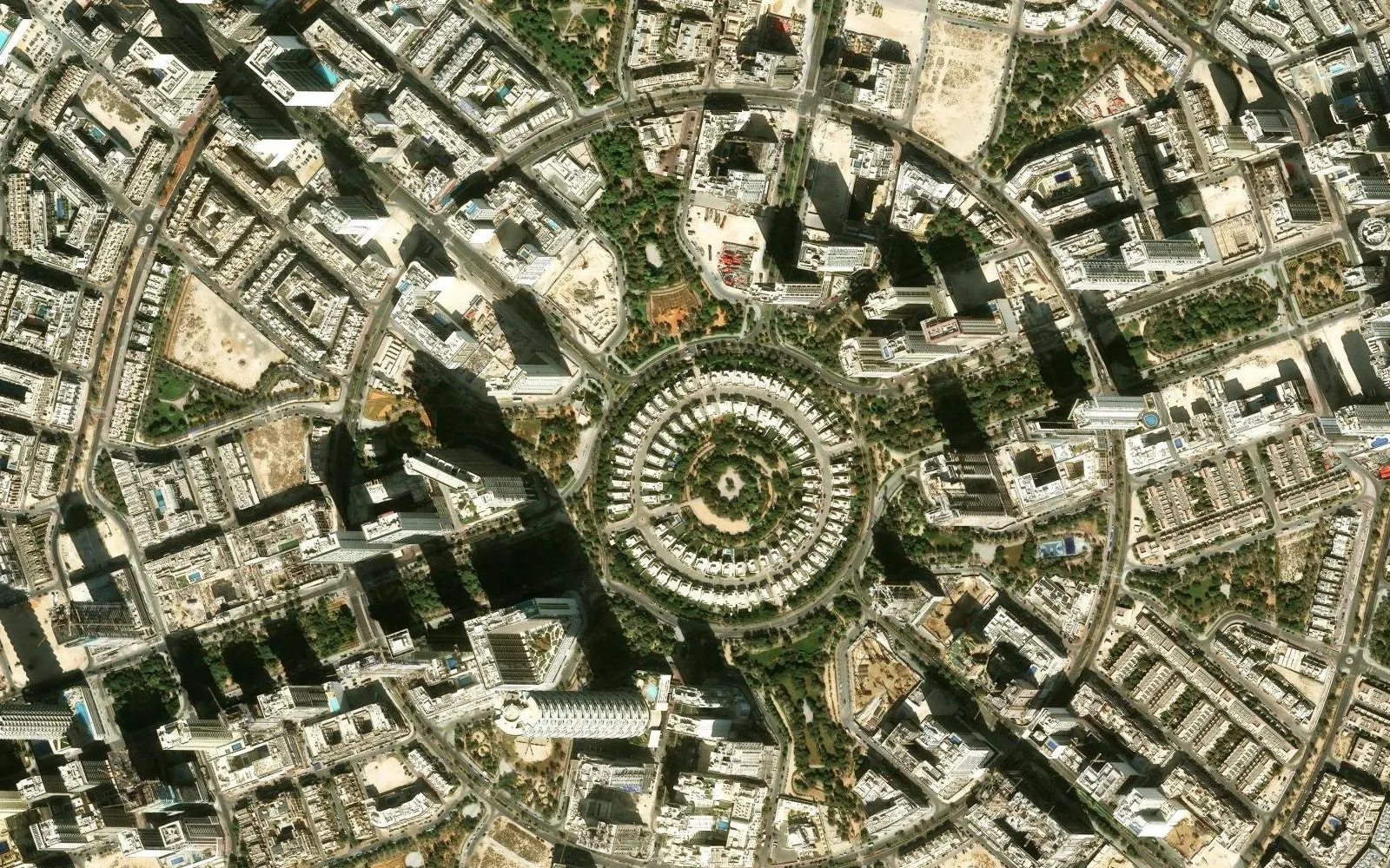 Satellite view of the centre of Jumeirah Village Circle: the ring of Nakheel villas around a central park, with apartment towers on every side
